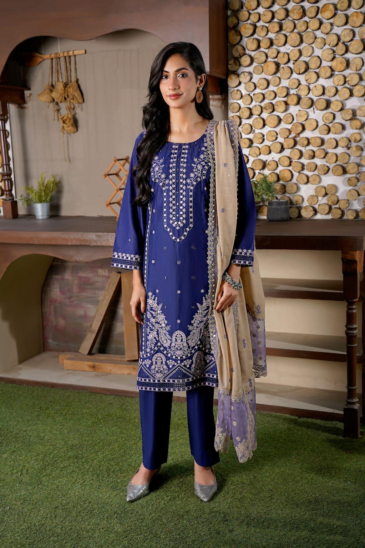 Woman in a royal blue embroidered salwar suit with a beige dupatta