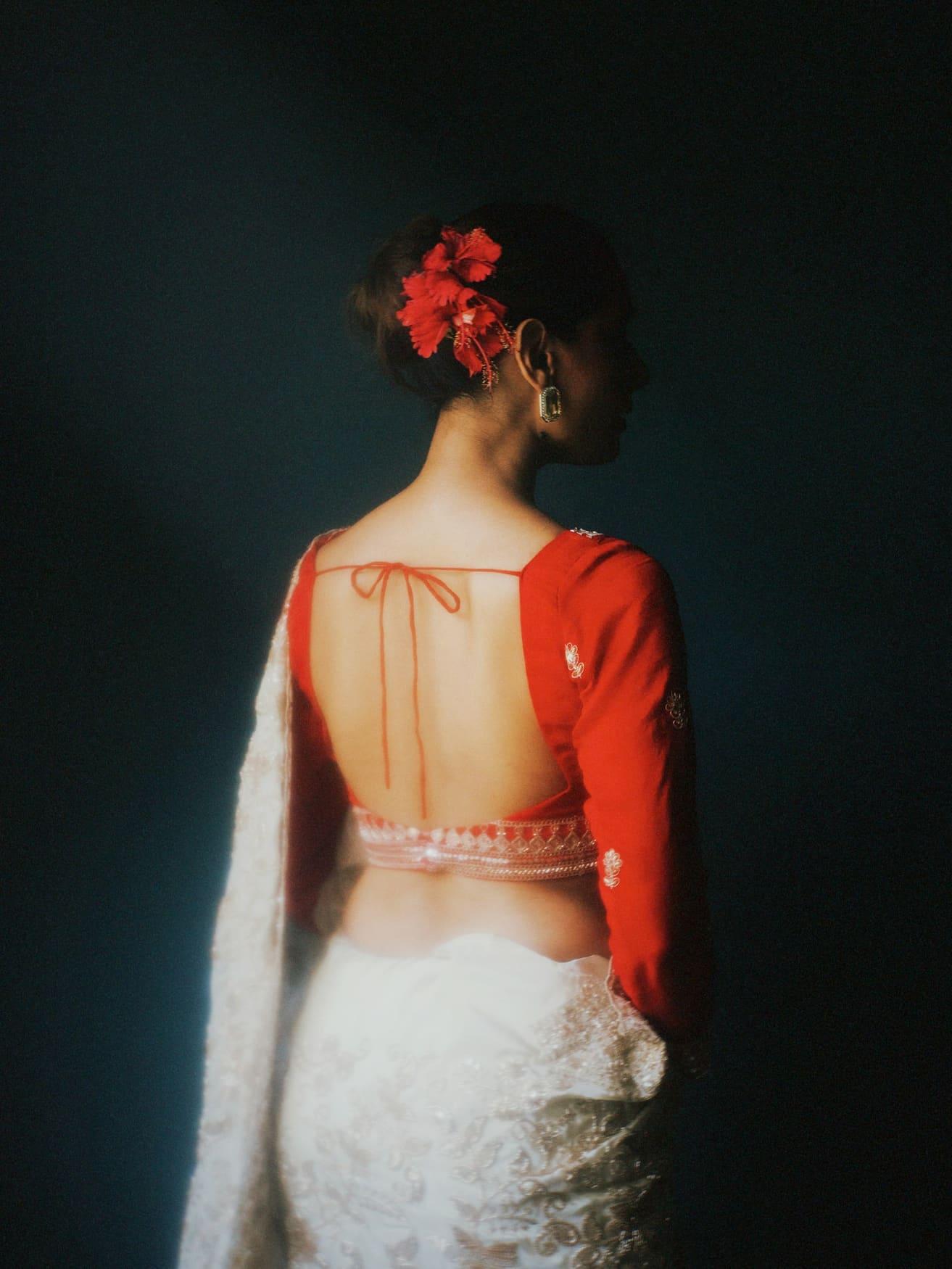 Back view of a red designer blouse with an open back and tie-up